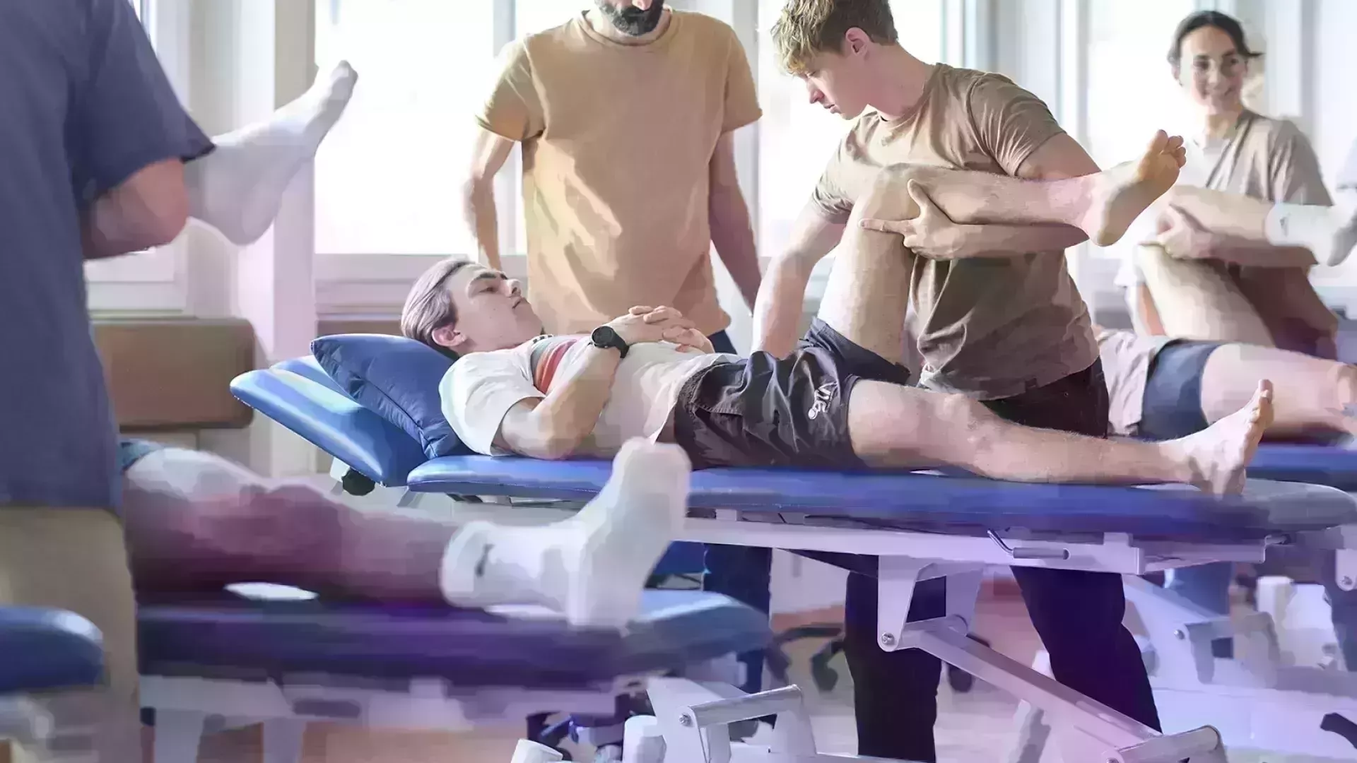 un patient et le physiothérapeute qui effecture une manipulation de la jambe