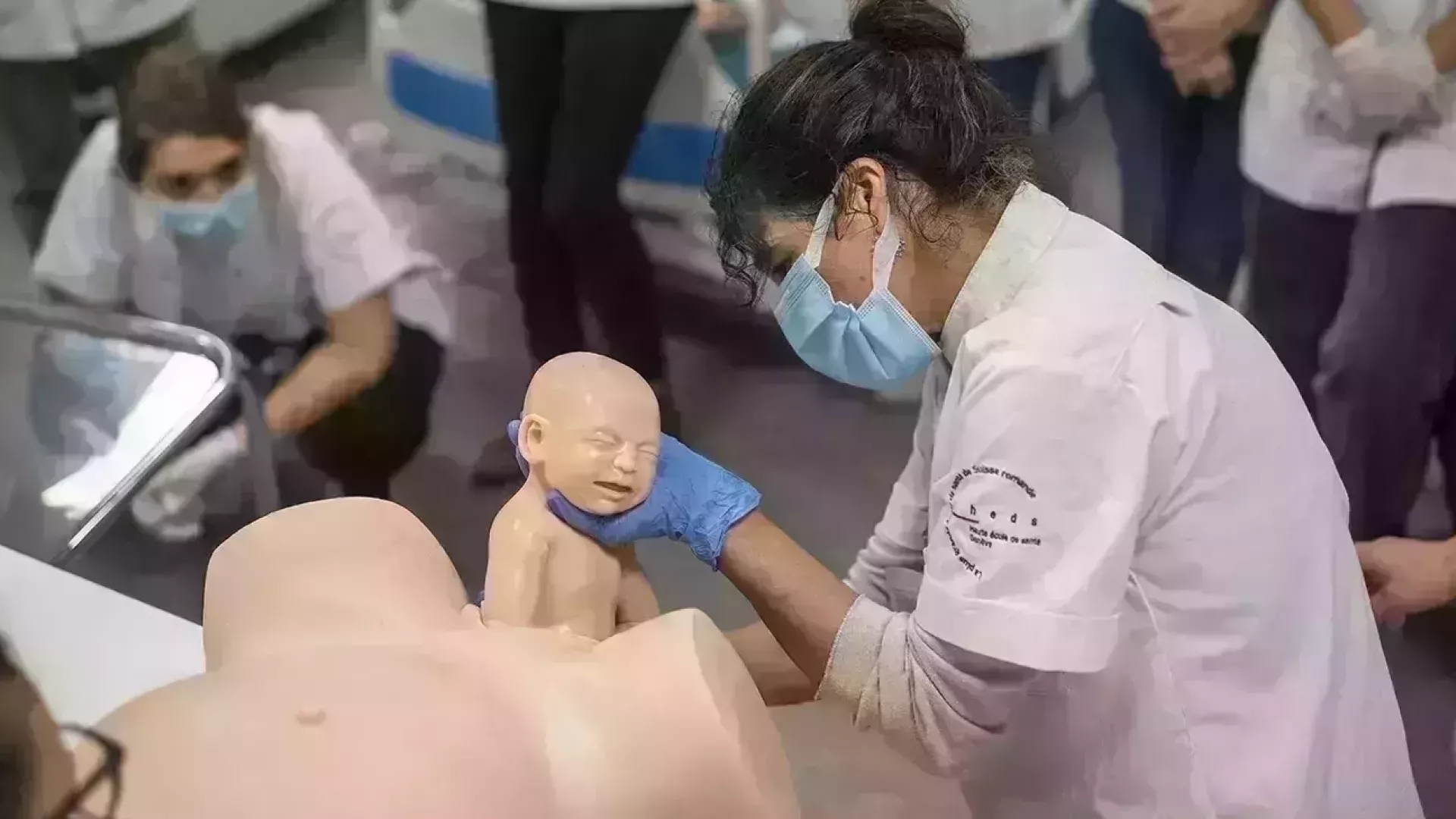 une sage-femme assistant l'accouchement d'un mannequin en tant que démontration