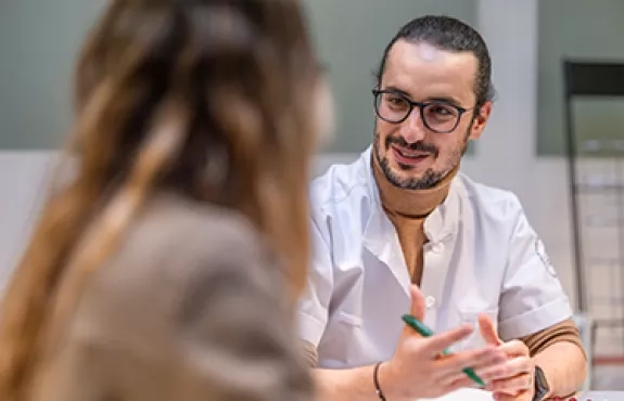 Une personne soignante échange avec une personne venue pour une consultation