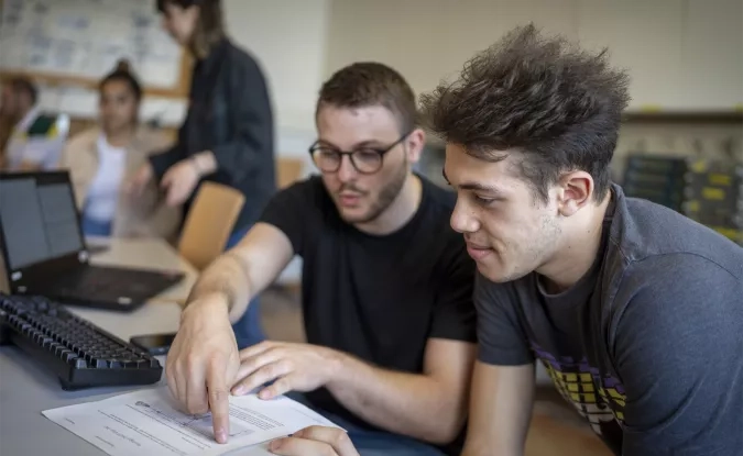 2 étudiants travaillant autours d'un ordinateur 