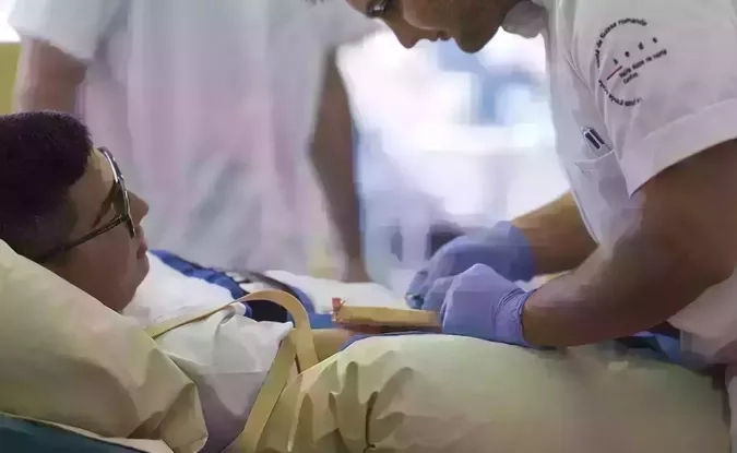 un patient et un infirmier qui effectue des soins