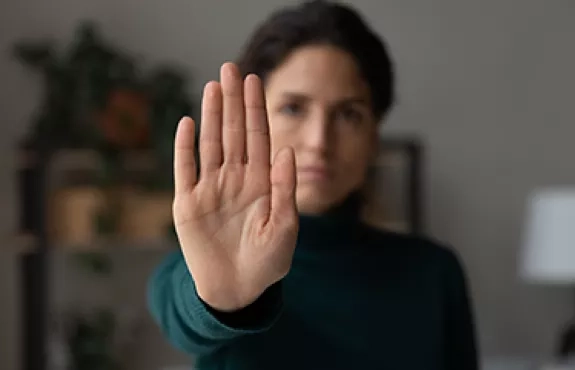 Une personne tend sa main devant elle pour signifier STOP