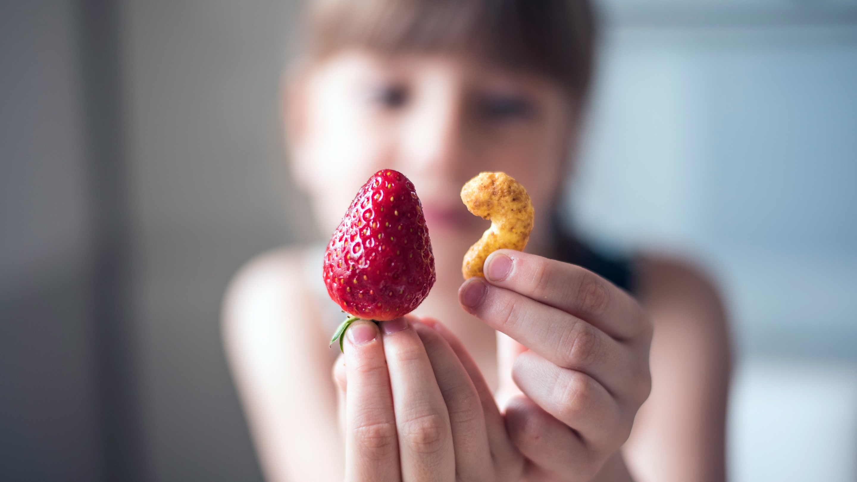 Photo d'une personne qui tient un fruit et un céréale en premier plan