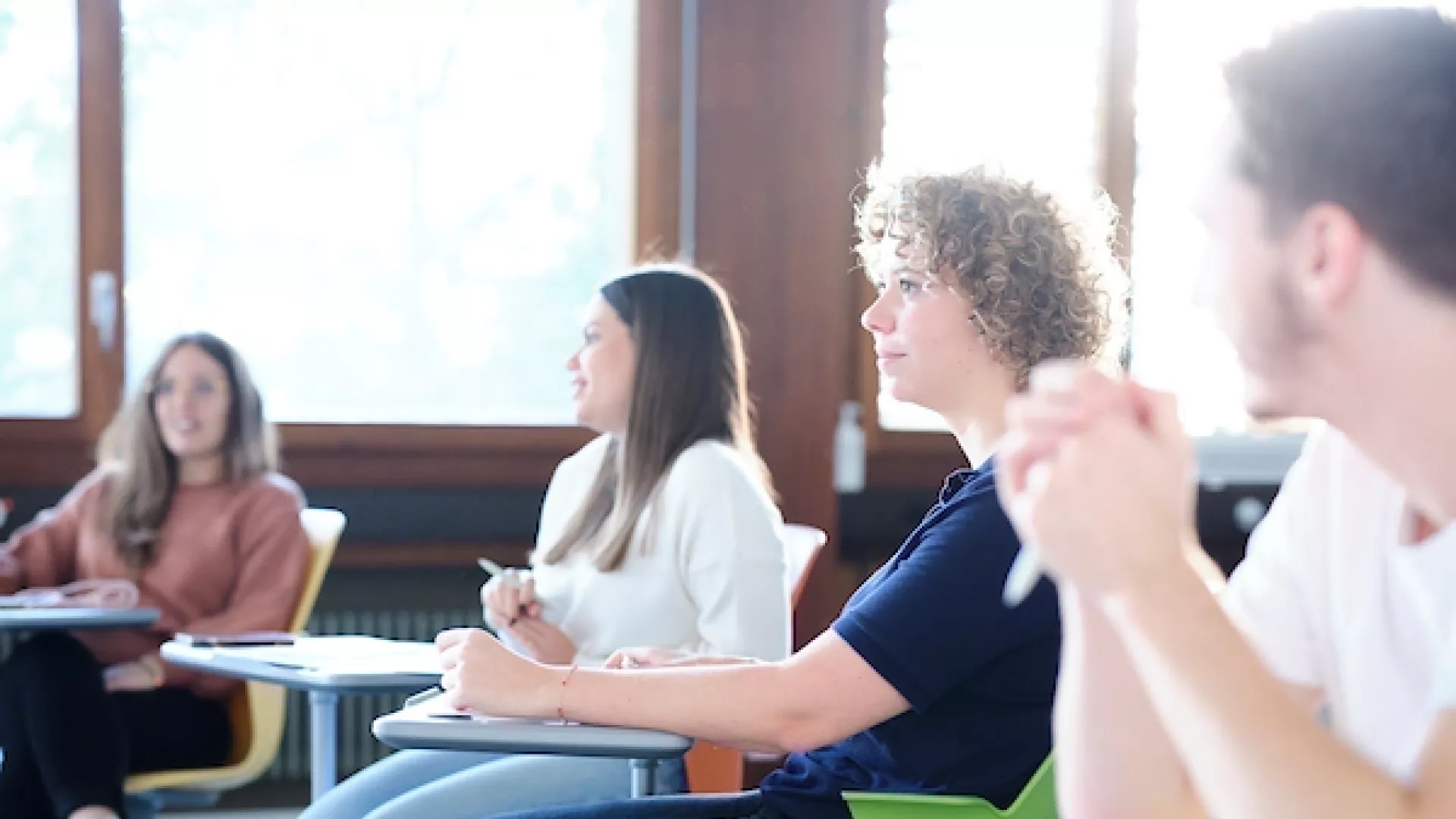 Salle de classe avec quatre étudiants qui suivent un cours