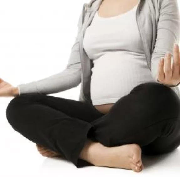 Photo d'une femme enceinte qui médite avec les jambes croisées