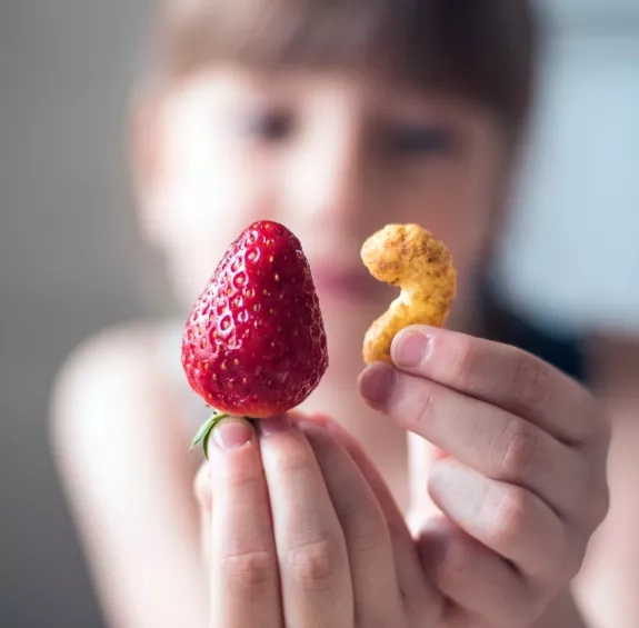 Photo d'une personne qui tient un fruit et un céréale en premier plan