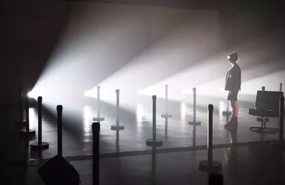 étudiante en contre-jour sur une scène parsemée de lumières 