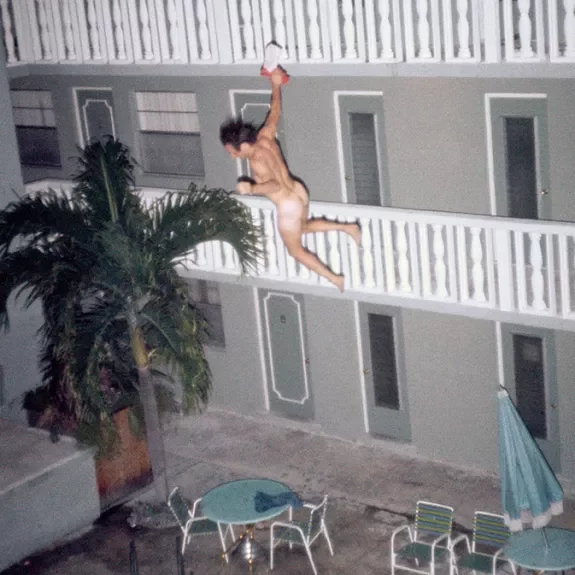 Homme qui saute d'un balcon dans une piscine