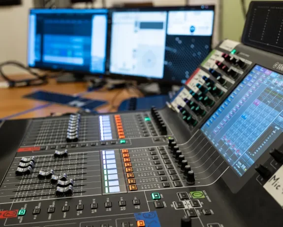 Photo d'une table de mixage avec des ordinateurs en arrière-plan