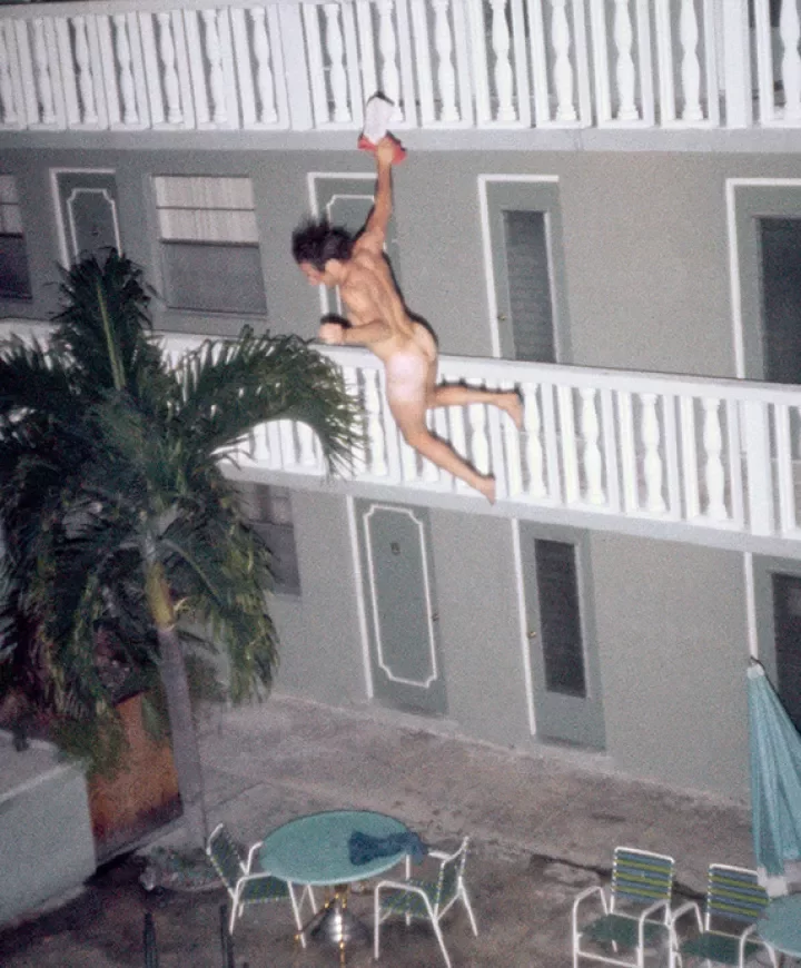 Homme qui saute d'un balcon dans une piscine