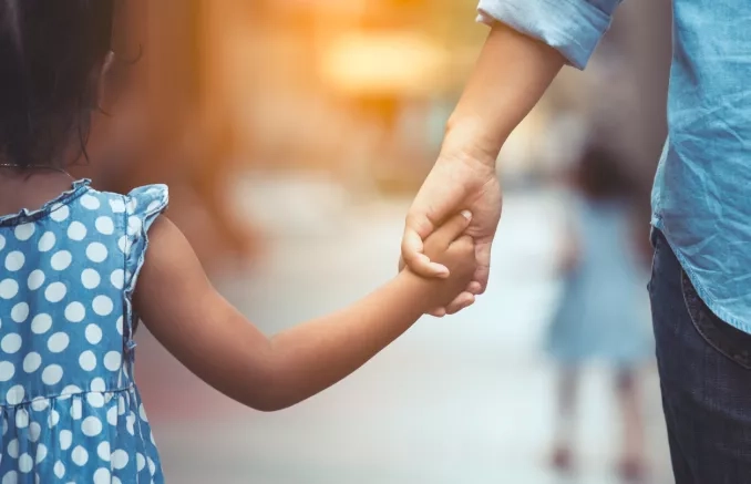 Enfant tenant la main d'un adulte