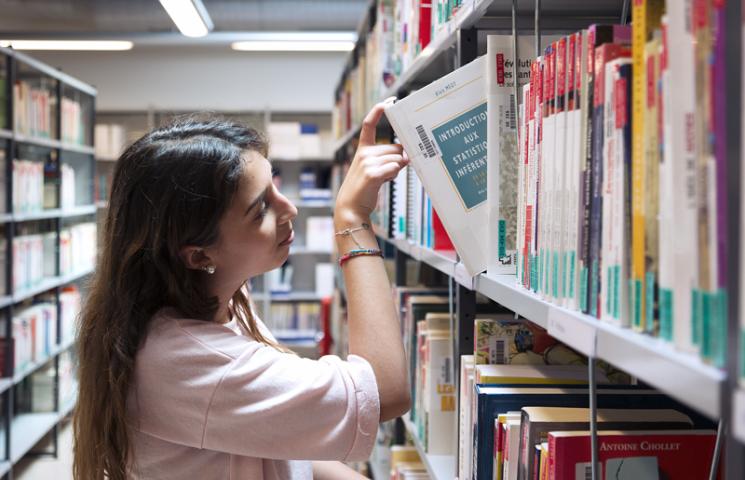 Etudiante qui choisit un livre