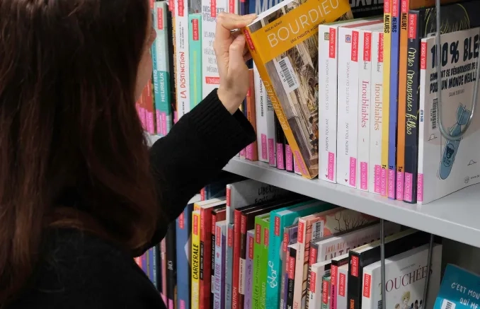 Etudiante qui choisit un livre